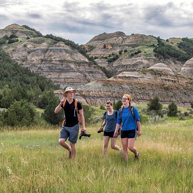 Three year-round campus students exploring the Badlands.