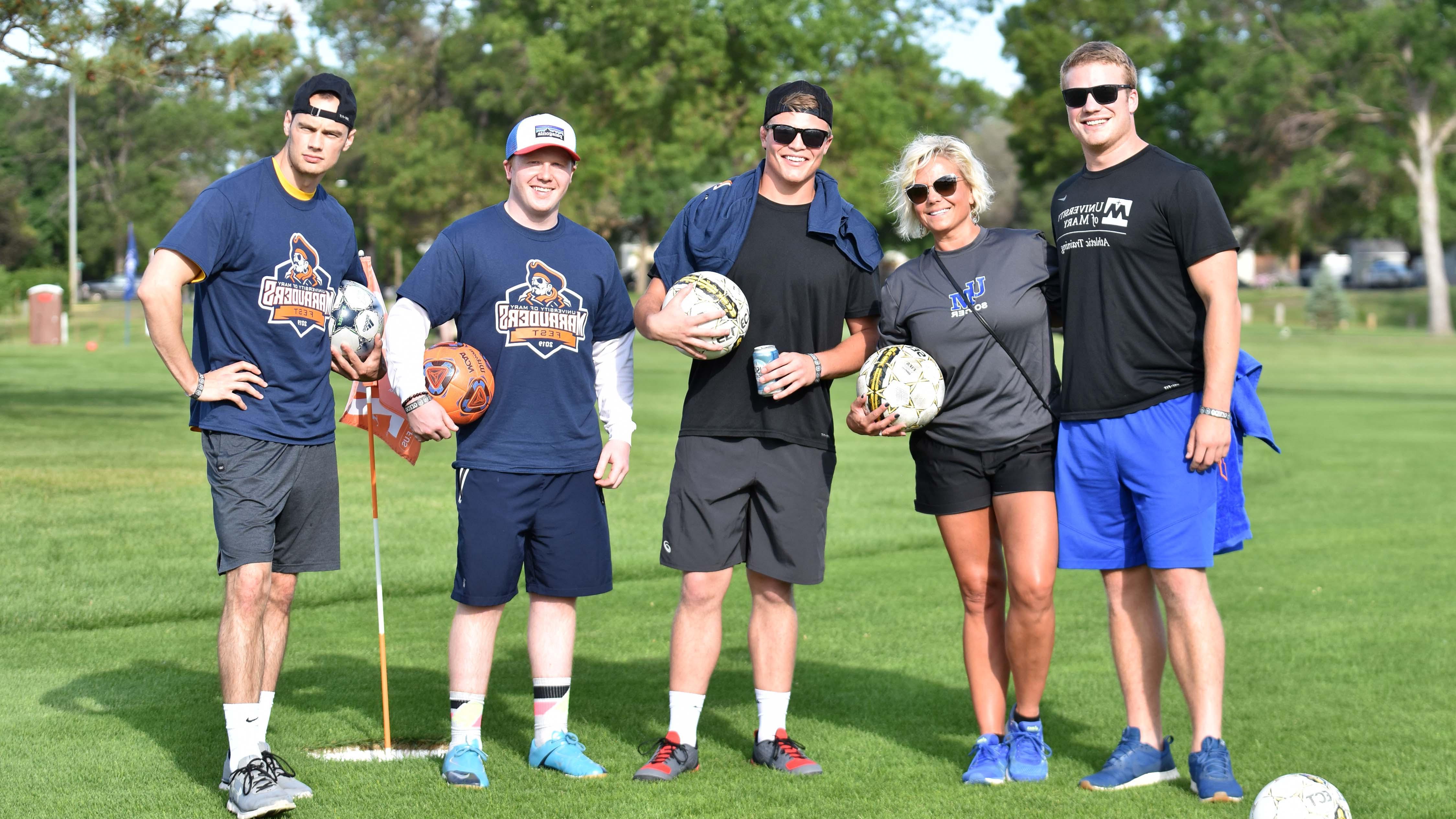 Five Marauders Fest participants holding soccer balls and smiling 